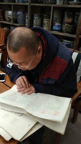 看到自己30年前在《滴翠》上的诗作，李炼既惊又喜。人民日报记者孔祥武摄(1)