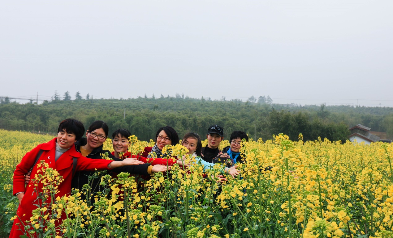 游人在油菜花田里合影留念.