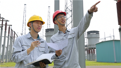 国网运行公司宜宾管理处复龙换流站站长王睿(右)给年轻同事讲解.